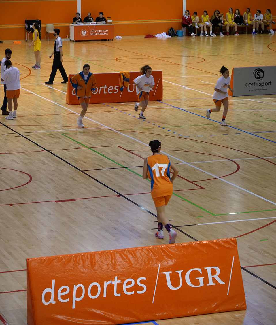 Calentamiento equipo baloncesto femenino Universidad de Cádiz  CAU2019 carrera. Detalle cartel naranja Deportes UGR