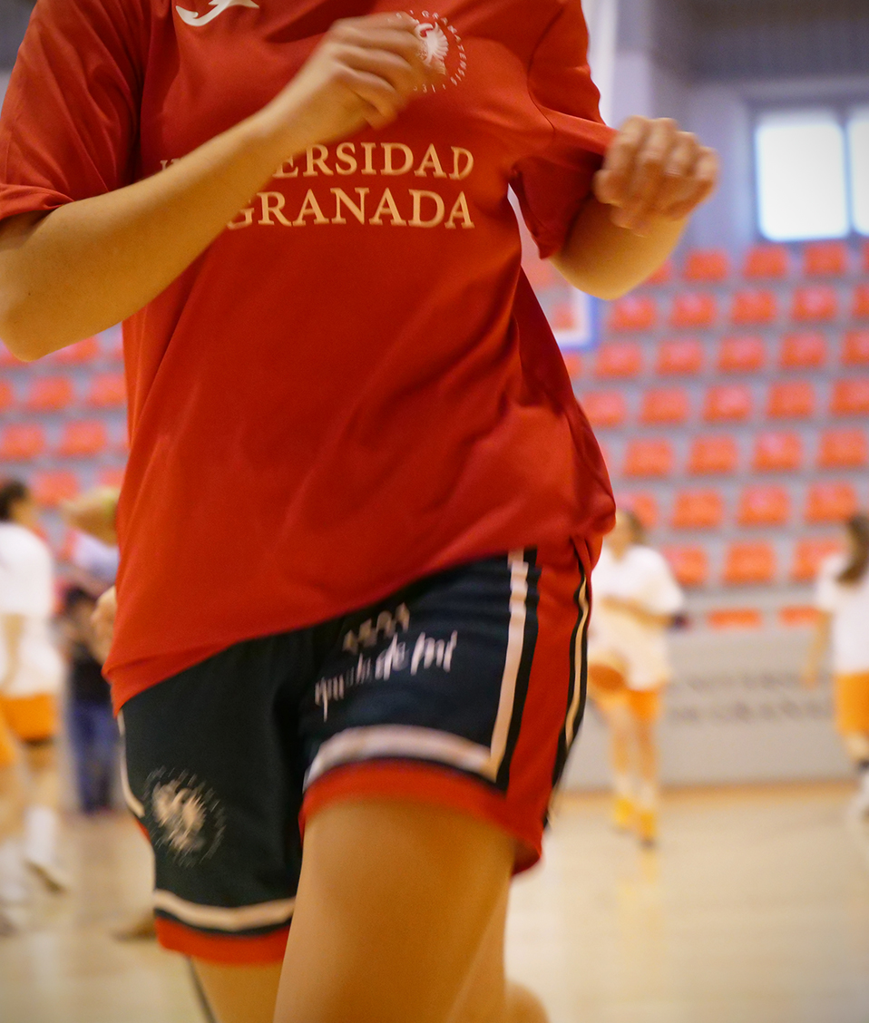 Calentamiento equipo baloncesto femenino Universidad de Granada CAU2019 detalle camiseta con texto y Escudo UGR